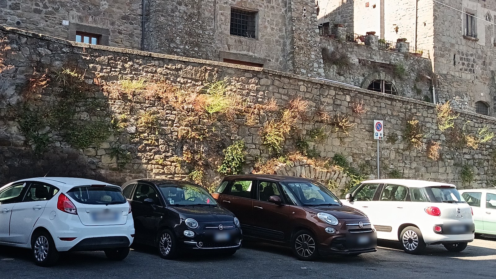 Automobili parcheggiate lungo le mura medievali del centro storico di Viterbo