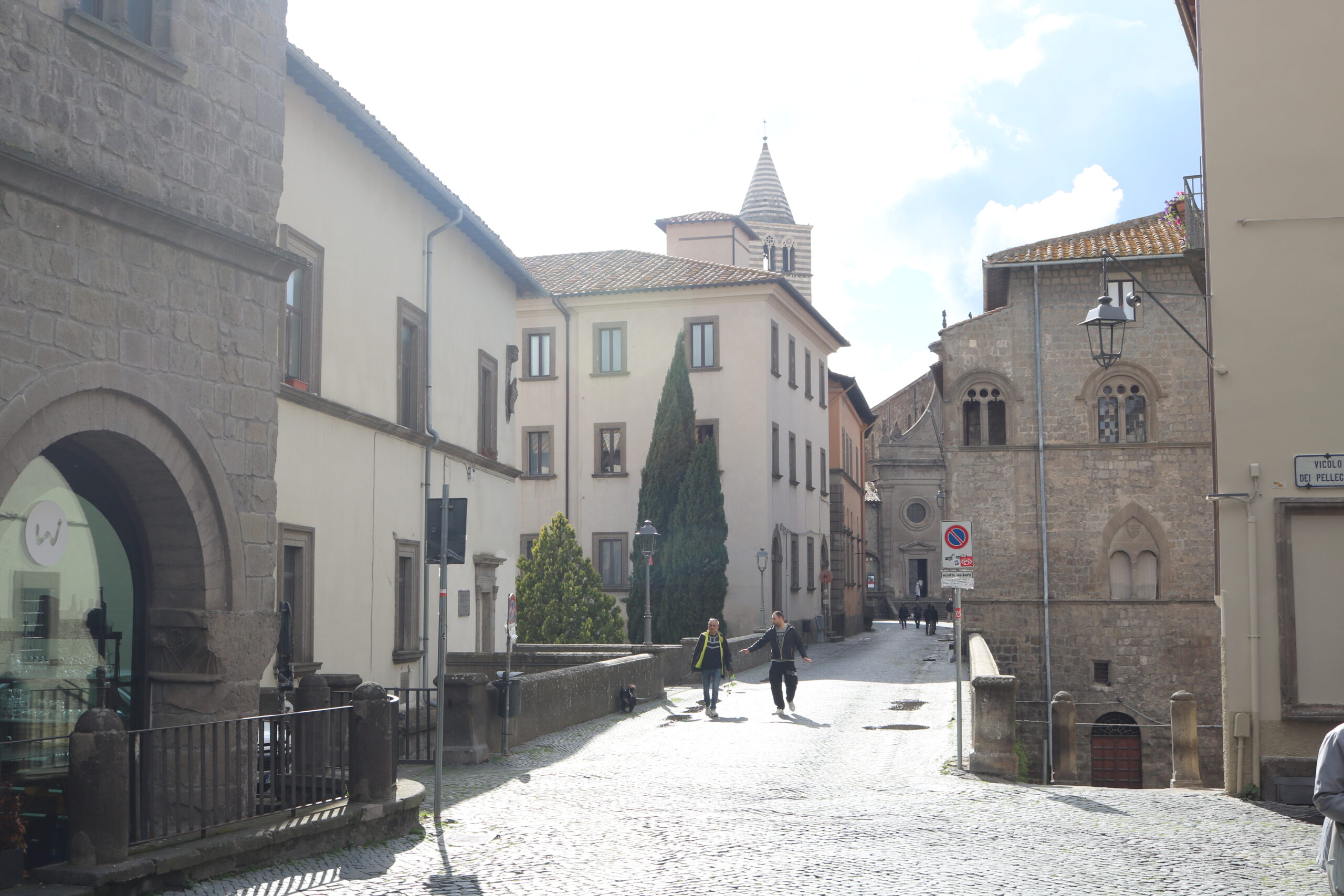 Strada acciottolata del centro storico di Viterbo, torre campanaria sullo sfondo