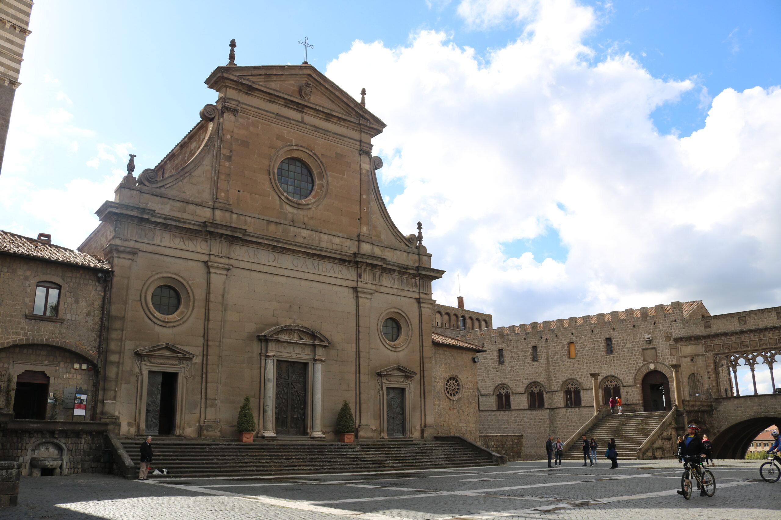 Piazza del centro storico di Viterbo con persone e Palazzo dei Papi sullo sfondo