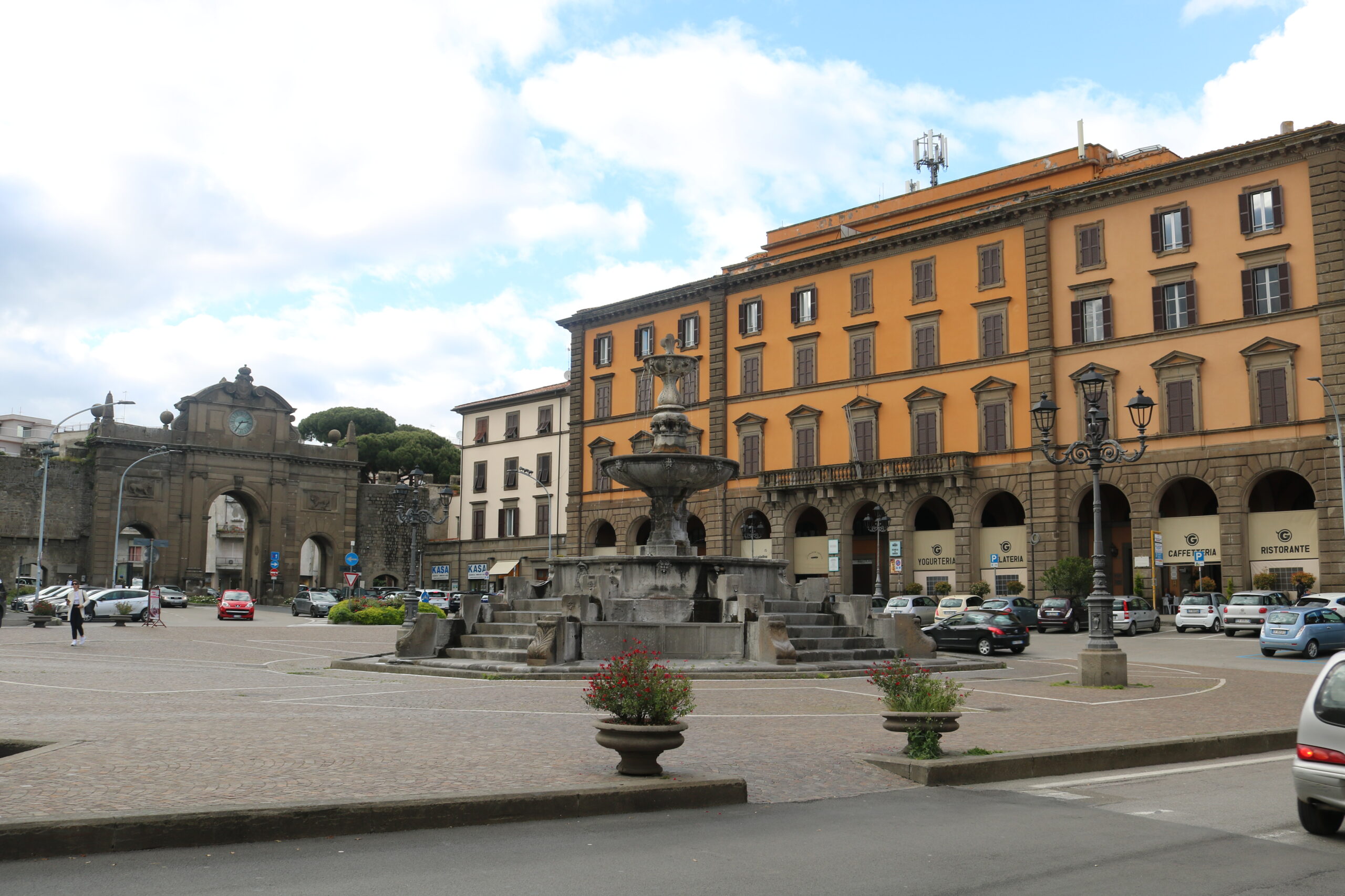 Piazza Fontana Grande a Viterbo, con la fontana monumentale circondata da automobili parcheggiate