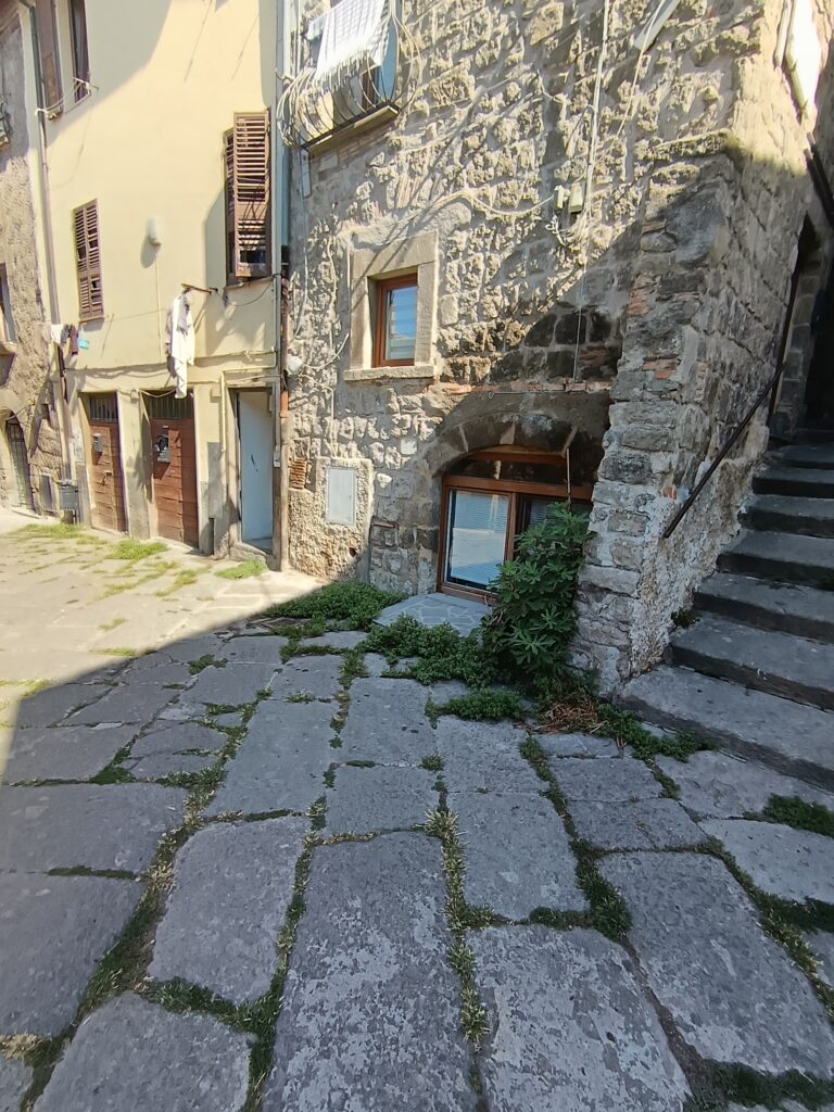 Vicolo lastricato in peperino con una scala esterna in pietra nel quartiere di San Pellegrino a Viterbo