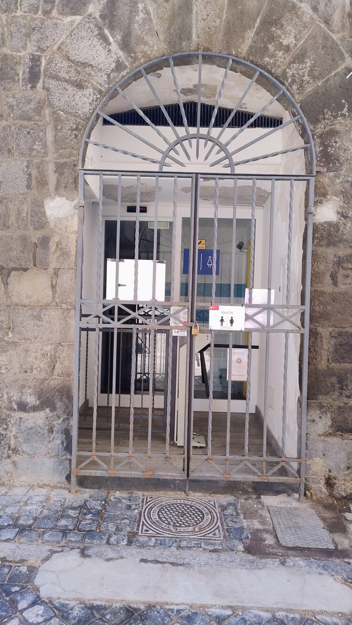 Ingresso di un bagno pubblico del centro storico di Viterbo, chiuso con lucchetto e cancello