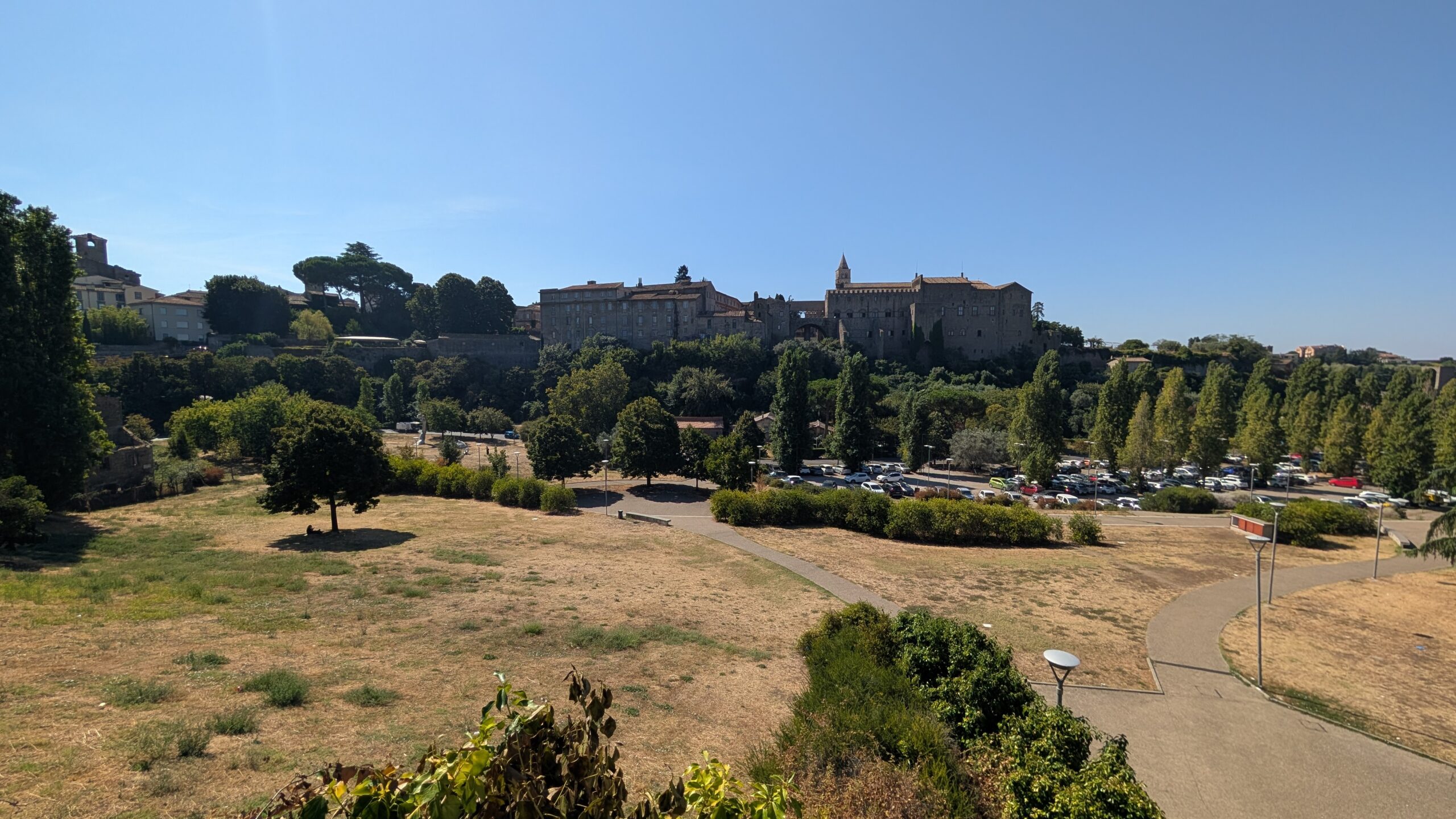 Valle Faul a Viterbo, prato secco in primo piano e Palazzo dei Papi sullo sfondo