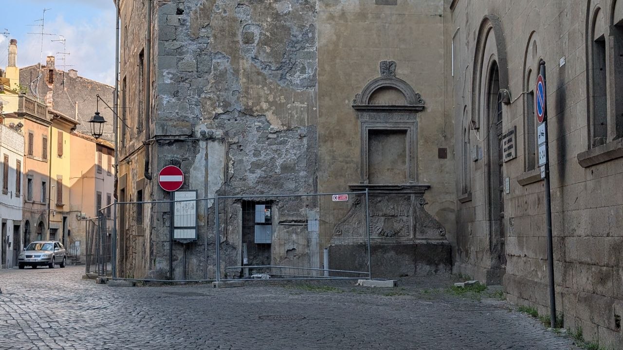 Il vicolo accanto al Palazzo Donna Olimpia con la fontana transennata sullo sfondo