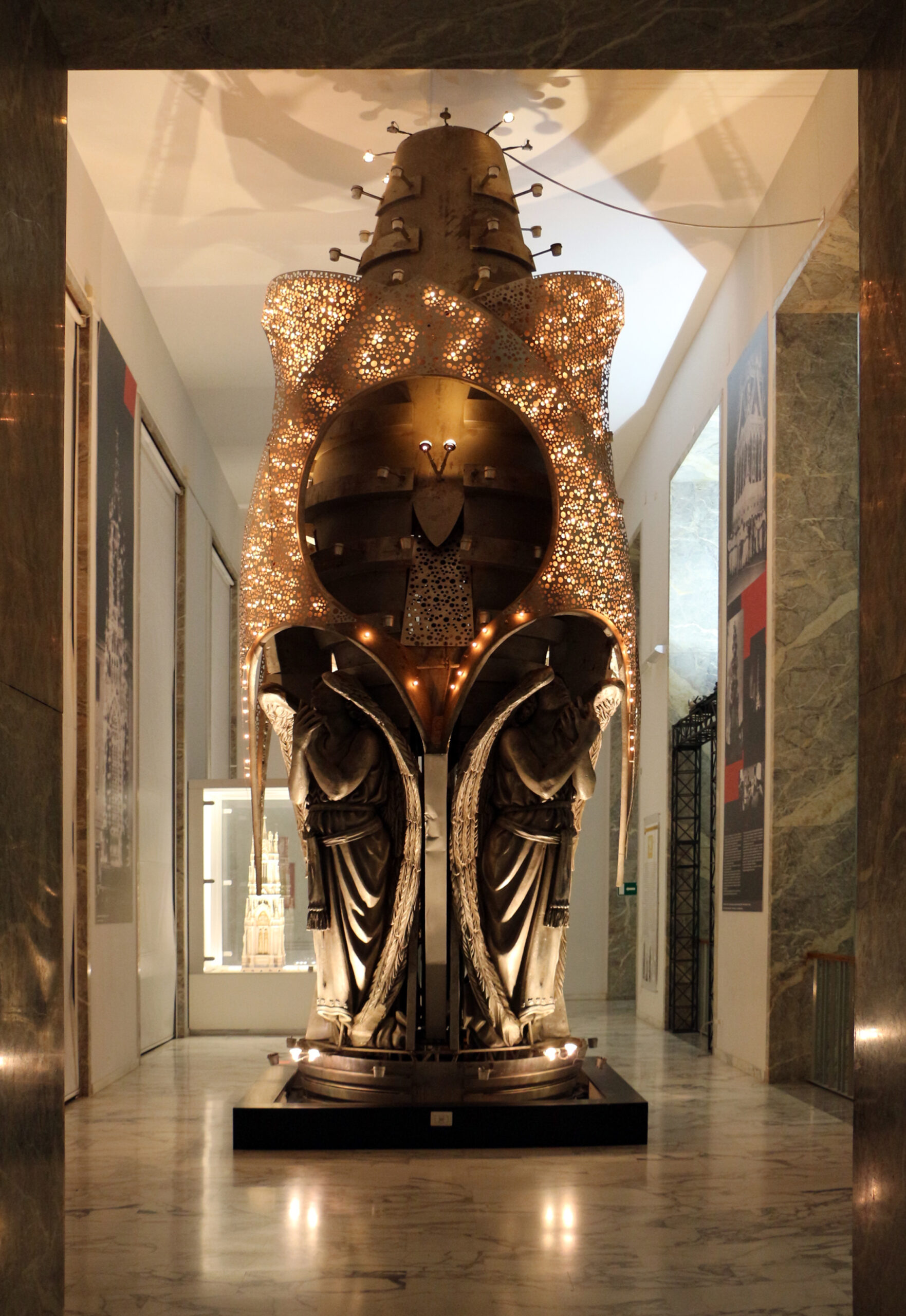Base illuminata di una storica Macchina di Santa Rosa, con due figure di angeli, esposta in un museo