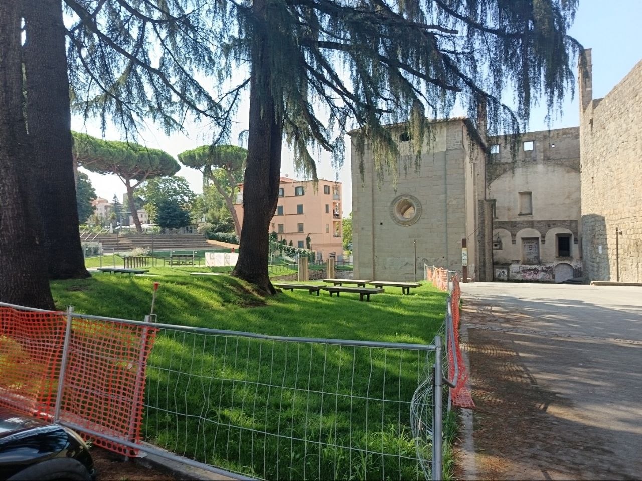 Tavoli e panchine all'ombra dei cedri, vicino all'ex chiesa delle Fortezze