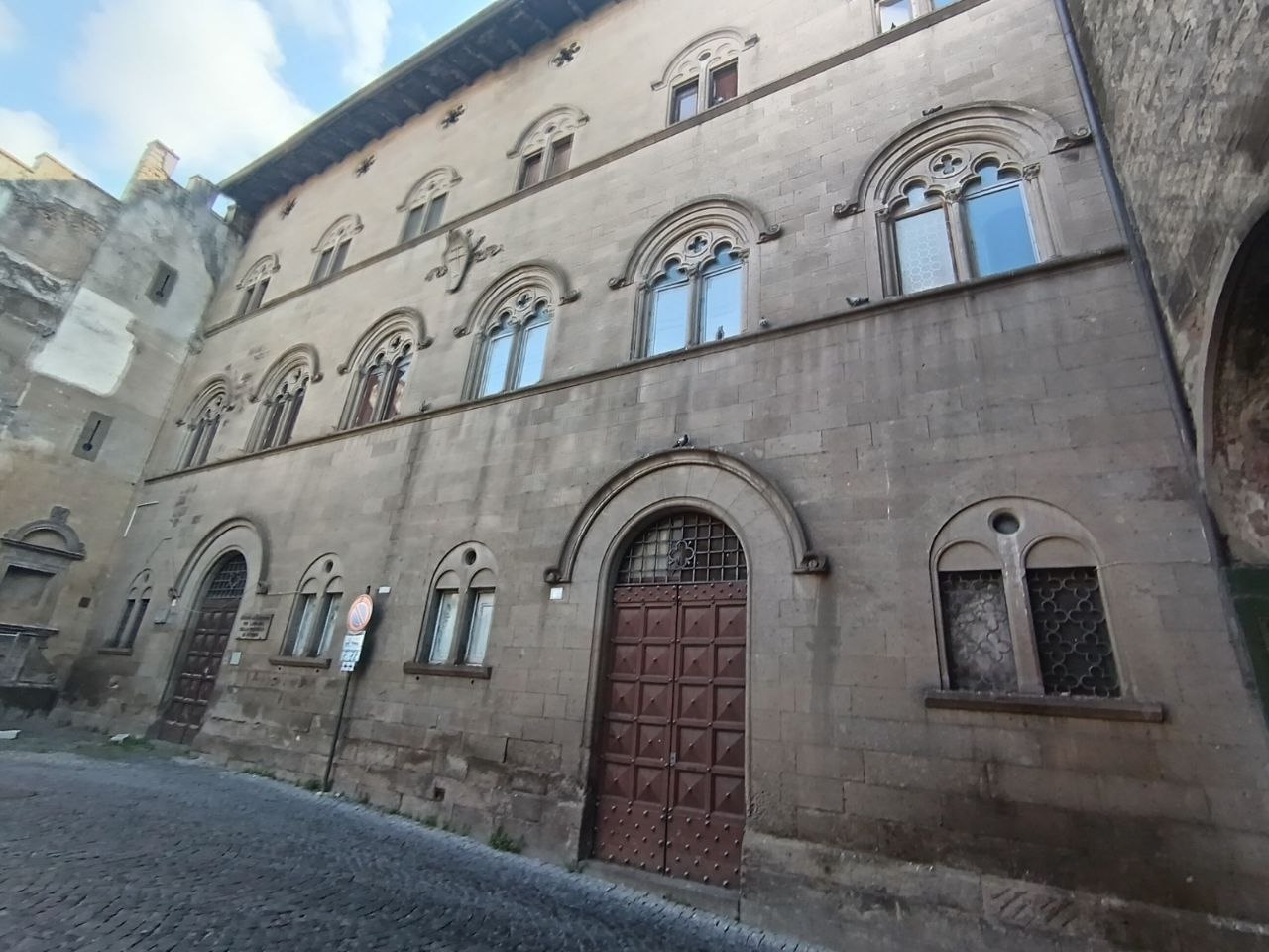 Palazzo Donna Olimpia a Viterbo, facciata principale con i due portoni: pietra annerita, finestre chiuse, nessun segno di attività