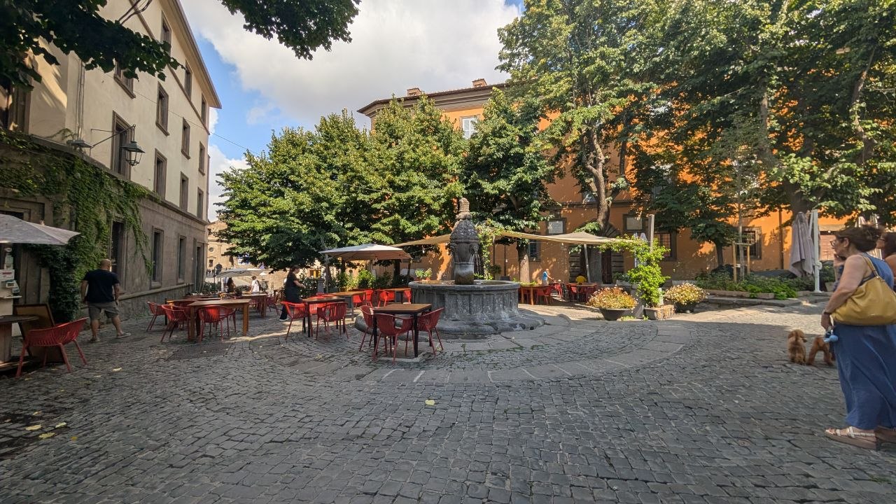 Piazza della Morte a Viterbo: tavolini, alberi e la fontana medievale al centro della piazza