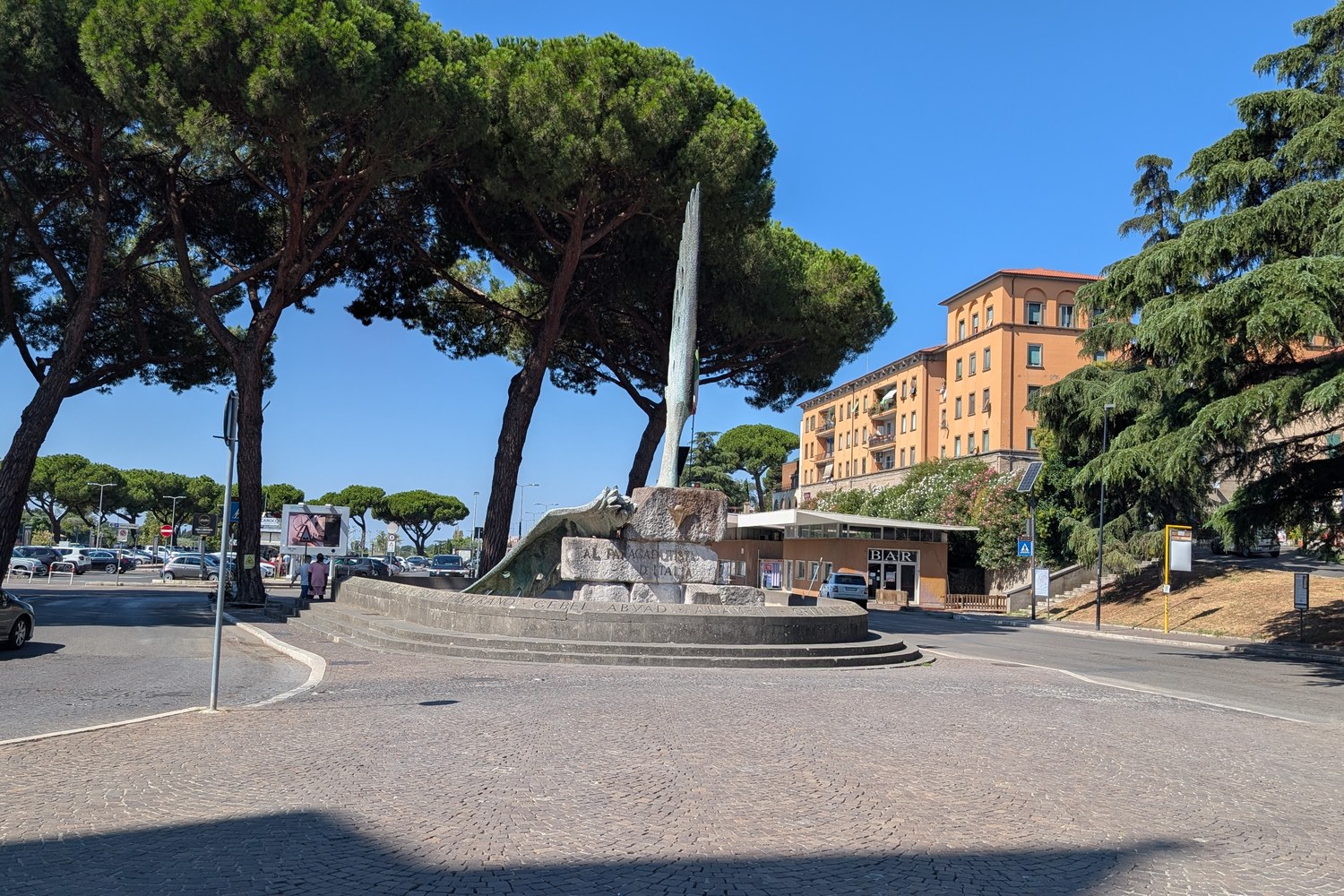 Traffico e pini marittimi a piazzale Gramsci, appena fuori le mura di Viterbo