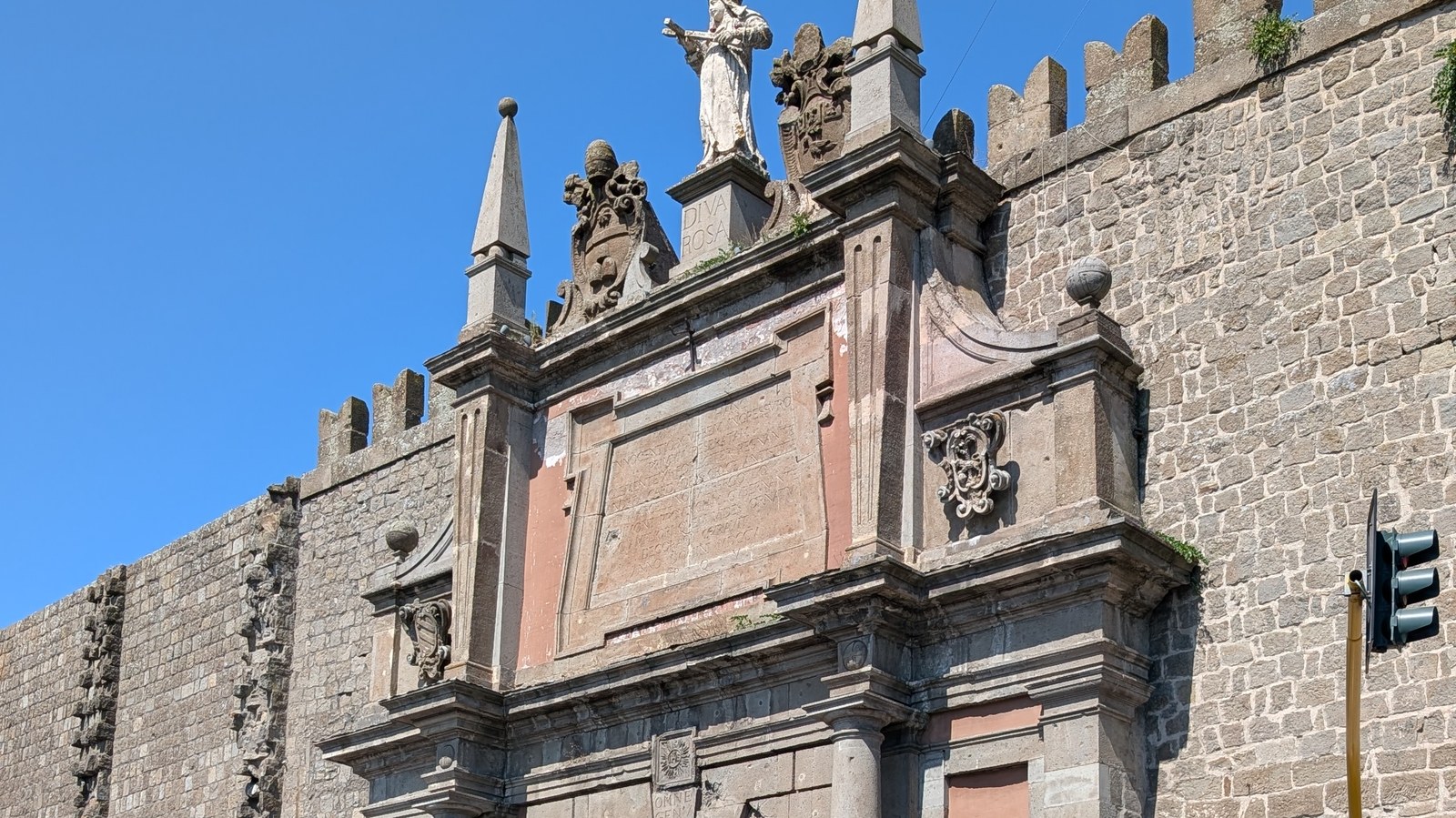 Il fastigio di Porta Romana a Viterbo con le mura in peperino e il cielo sereno