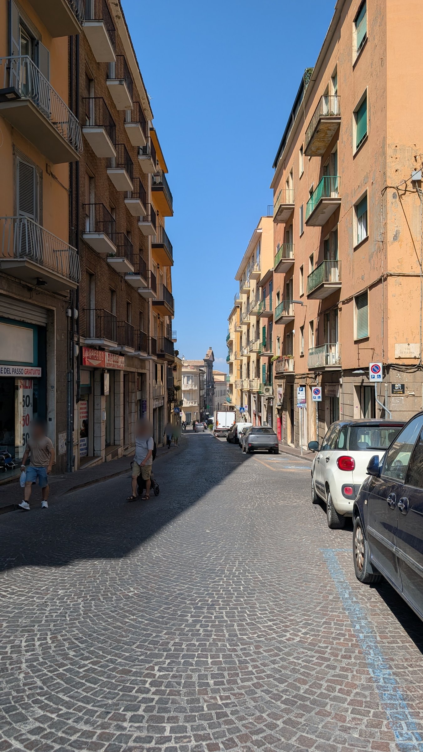 Auto in sosta e pedoni in una via del centro di Viterbo