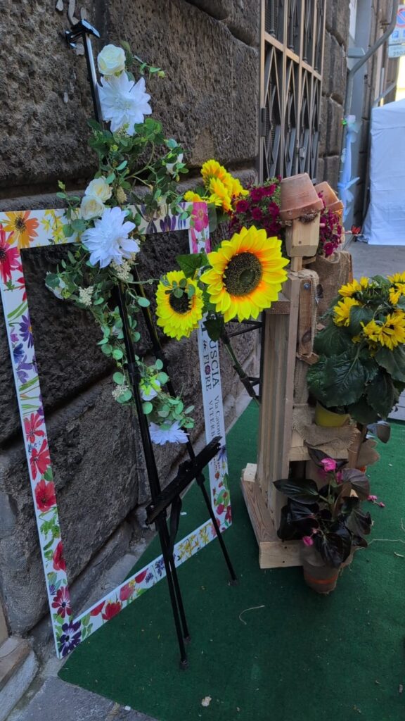 Una cornice decorata con fiori finti in via Cavour