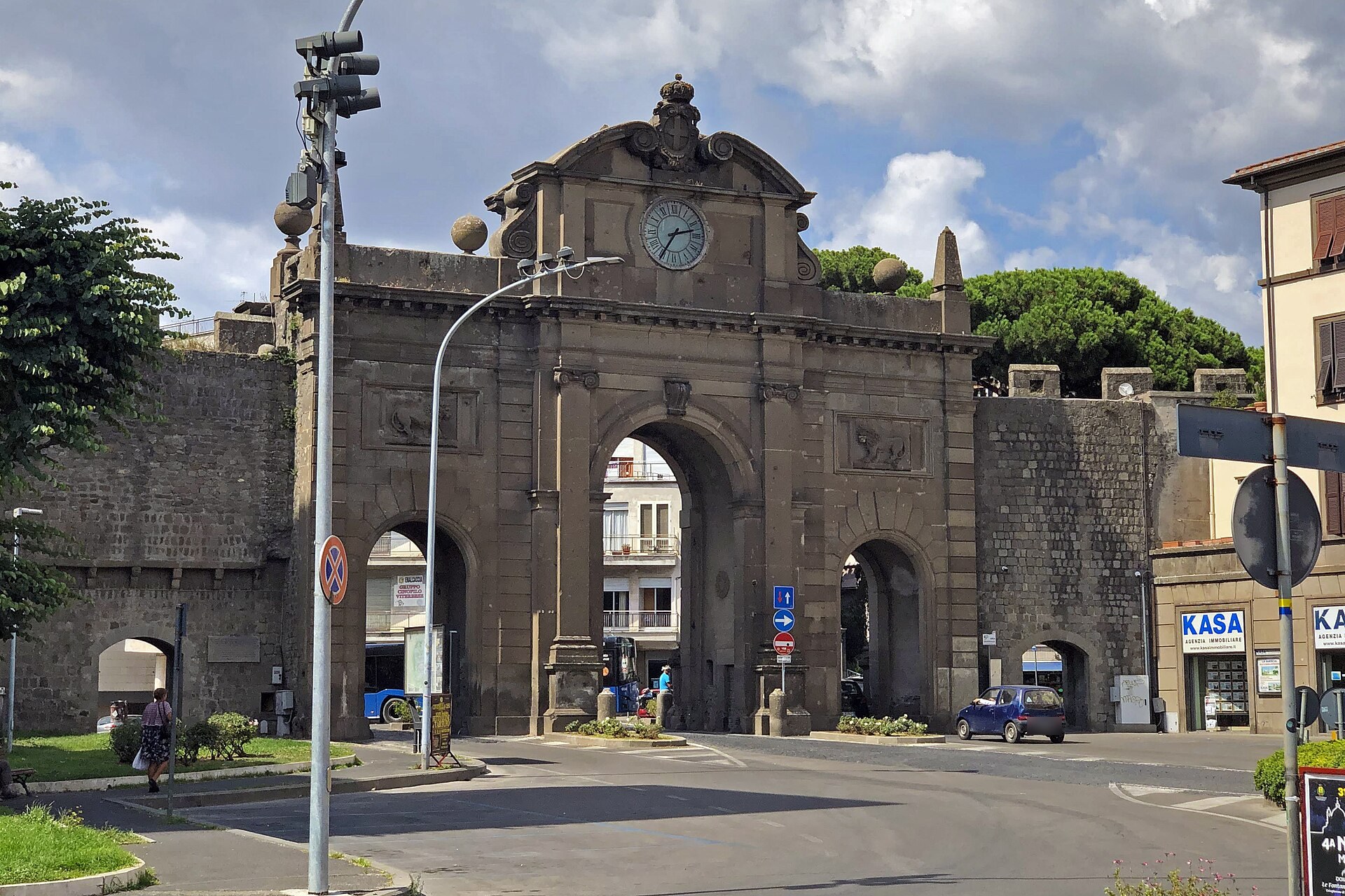 Porta Fiorentina a Viterbo vista dall'interno delle mura, con la torre dell'orologio e i pini di piazzale Gramsci oltre le mura