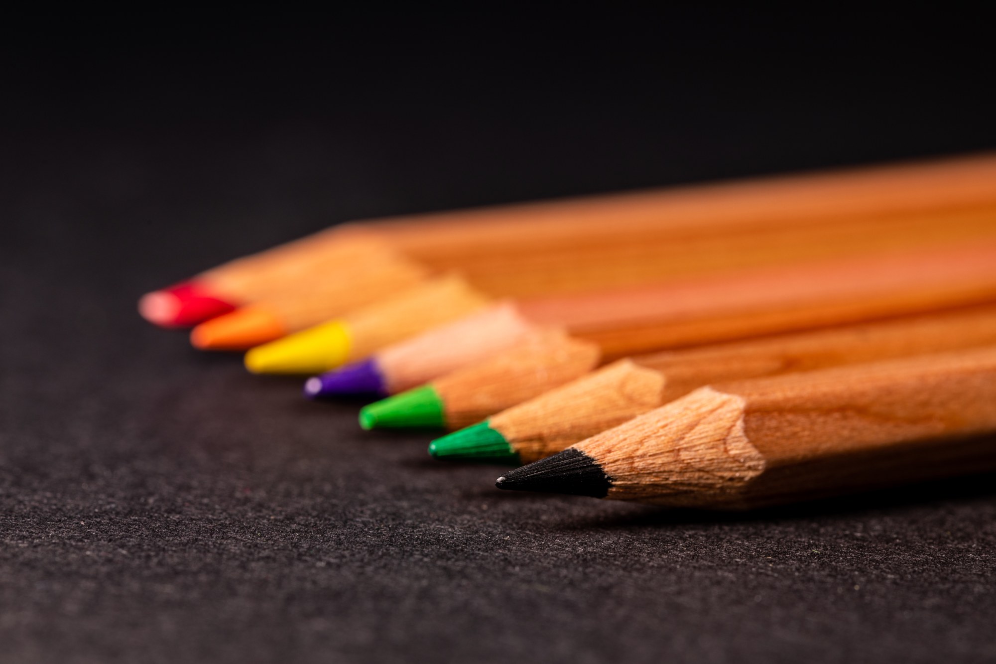 Matite colorate appoggiate su un fondo scuro, immagine di repertorio per una notizia sulla scuola dell'infanzia