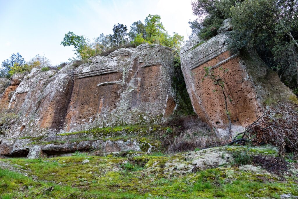 Facciate di tombe etrusche scolpite nella parete di tufo, fra muschio e alberi, nella necropoli di Norchia