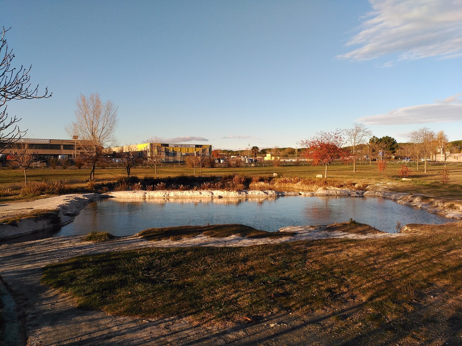 Una vasca termale delle Piscine Carletti, a Viterbo, in una giornata d'autunno, con il prato e gli alberi sullo sfondo