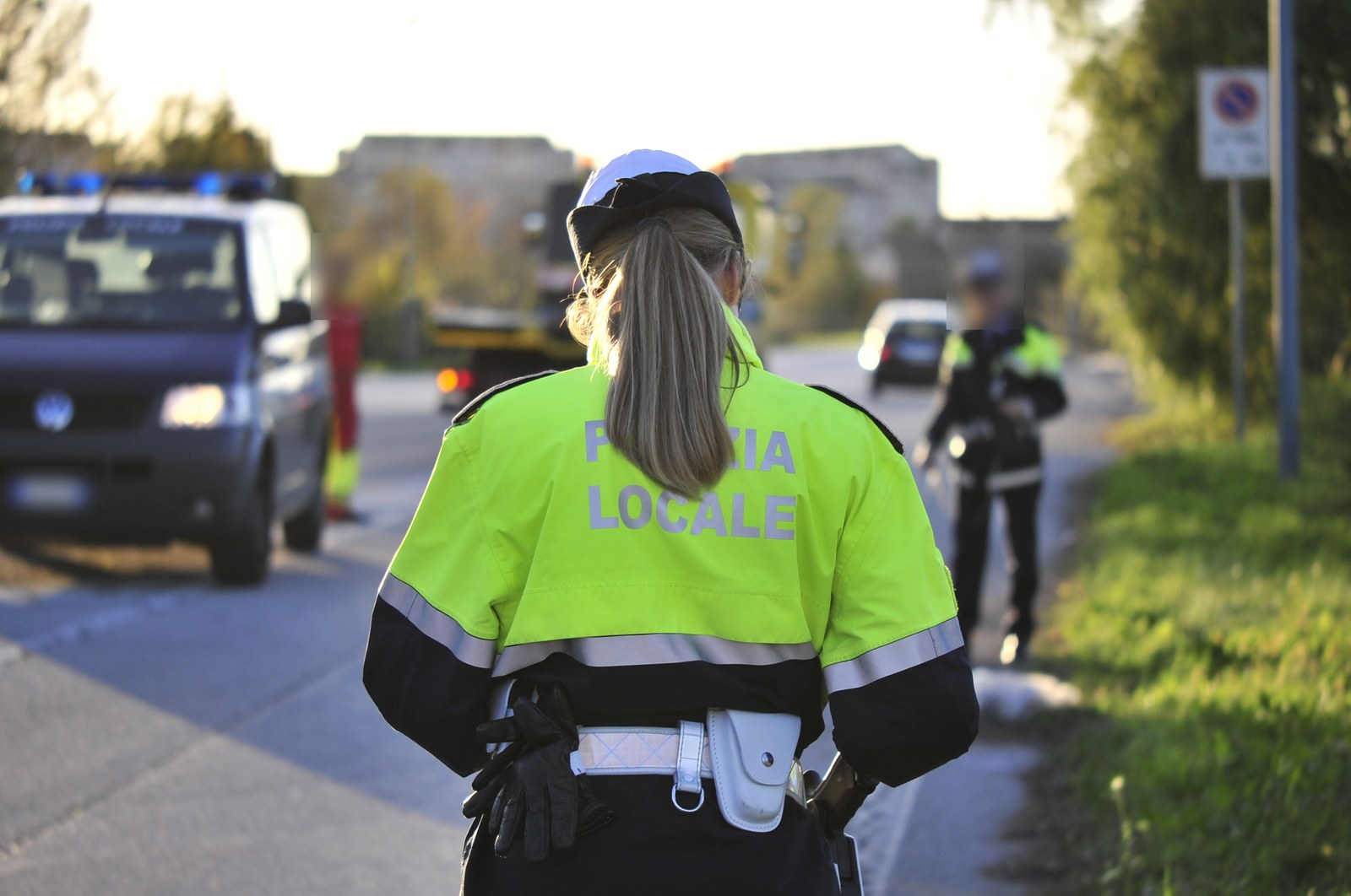 Un’agente della Polizia locale, di spalle, durante un servizio su strada