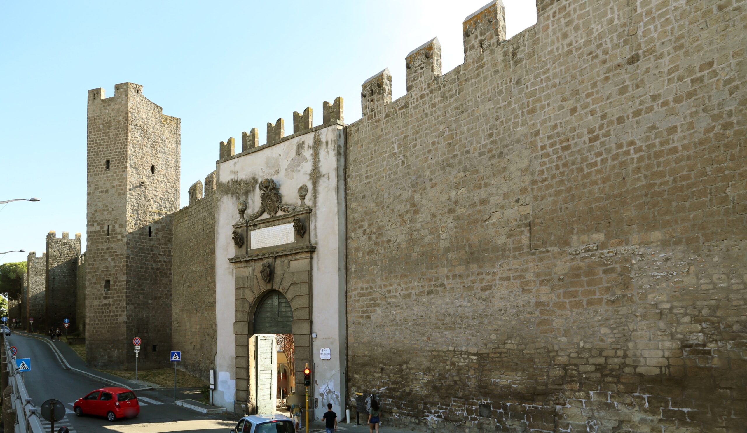 Porta della Verità a Viterbo con le ante in legno, gli stemmi in sommità e le mura merlate