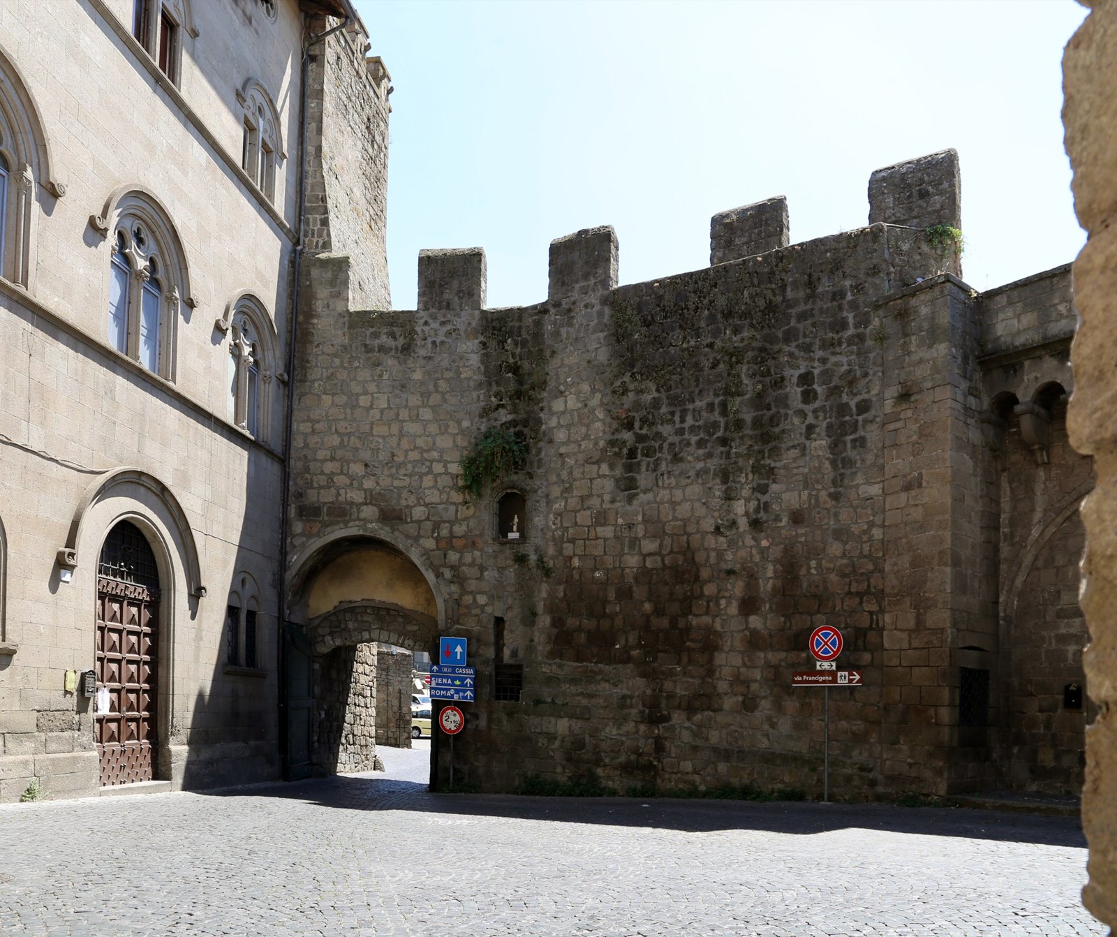 Porta San Pietro vista dall’interno delle mura, con l’arco in peperino e la porta in legno aperta