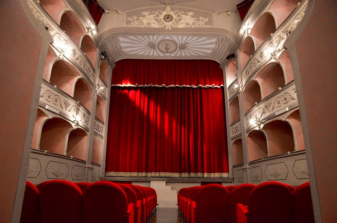 La sala del Teatro Boni di Acquapendente con i palchi e il sipario rosso