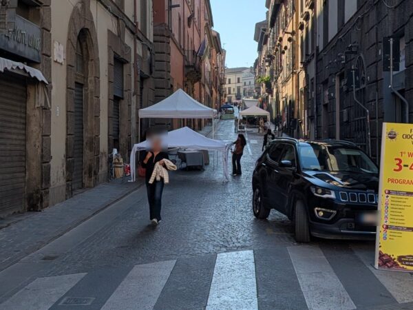 Via Cavour a Viterbo con i gazebo bianchi del Cioccotuscia in allestimento e il cartello del festival
