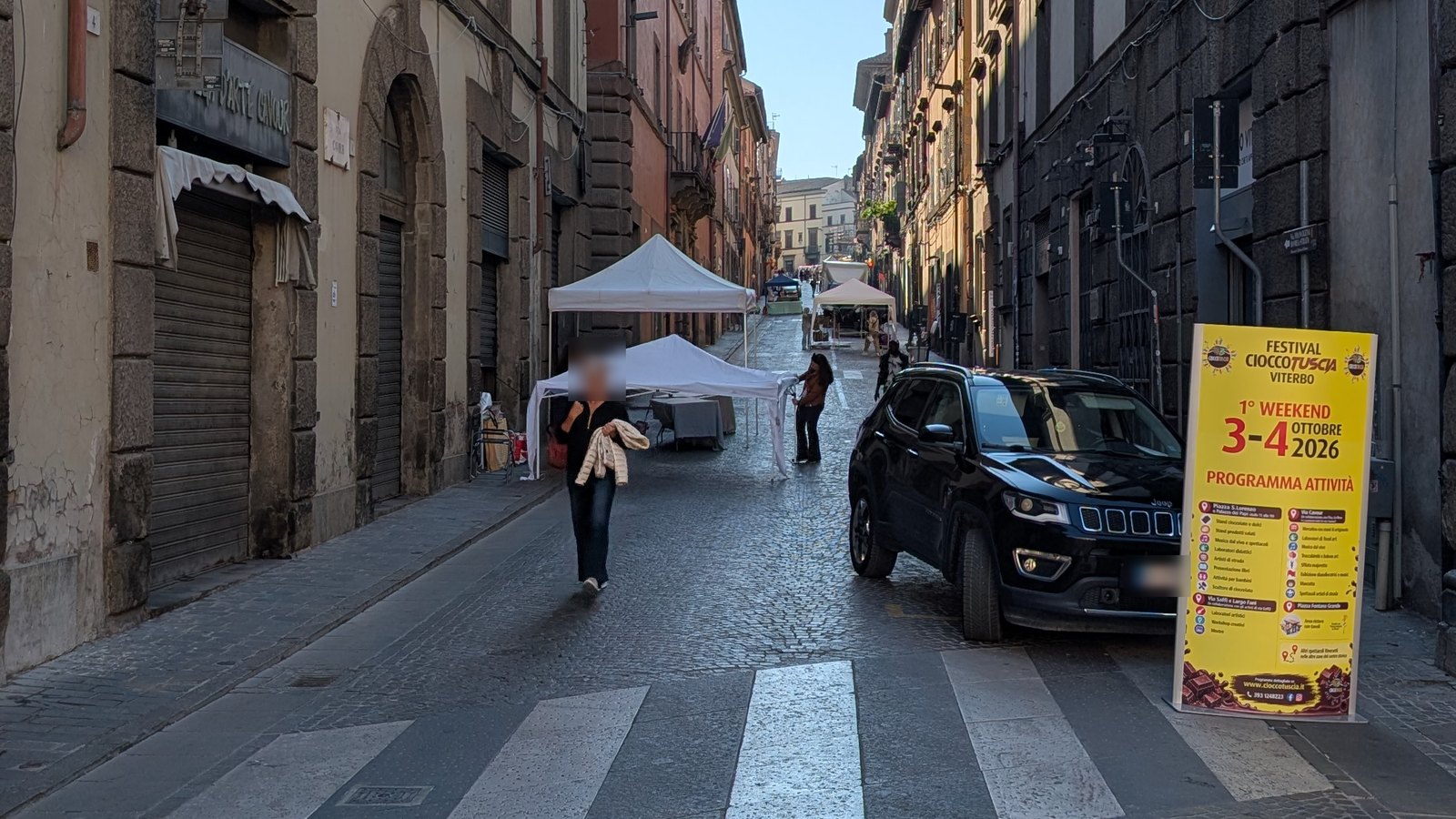 Via Cavour a Viterbo con i gazebo bianchi del Cioccotuscia in allestimento e il cartello del festival